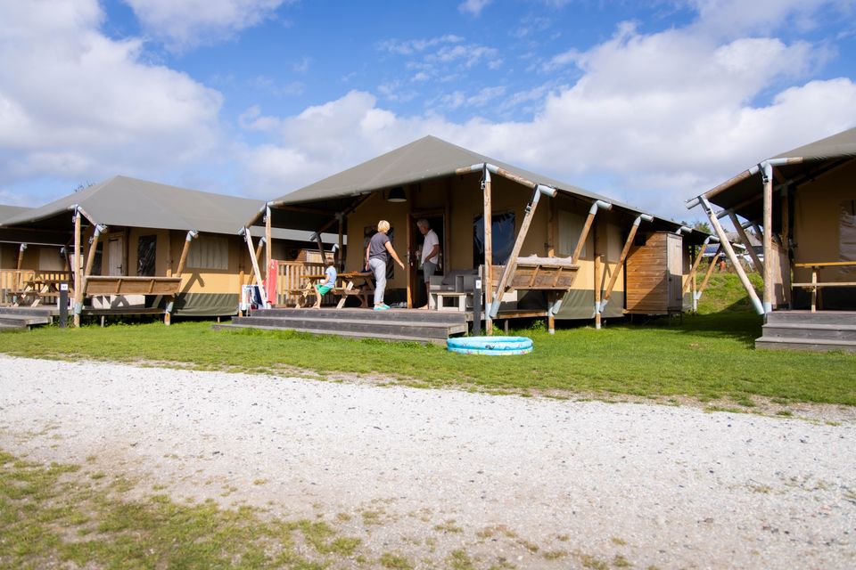 Kampeerplek met tent en uitzicht op de Waddenzee in Friesland.