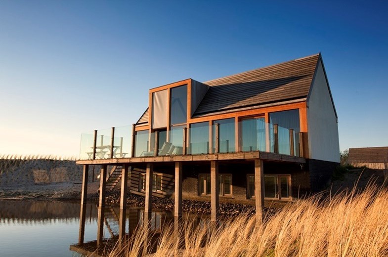 Waddenlodge met uitzicht op de Waddenzee bij zonsopgang.